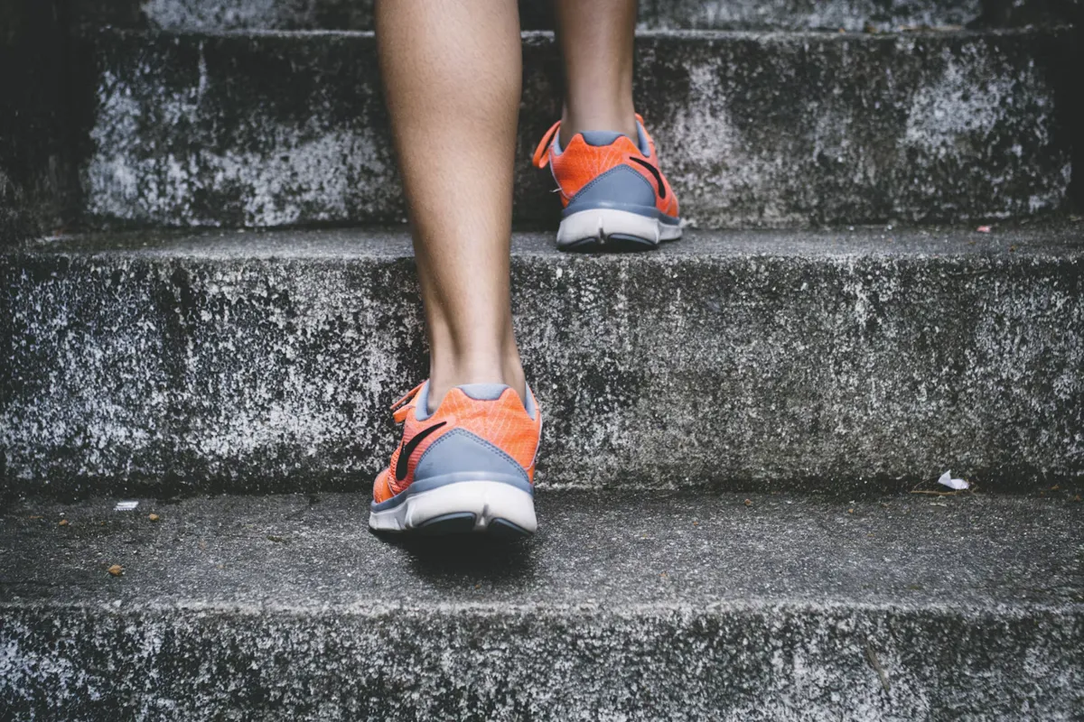Runner in orange shoes climbing concrete stairs